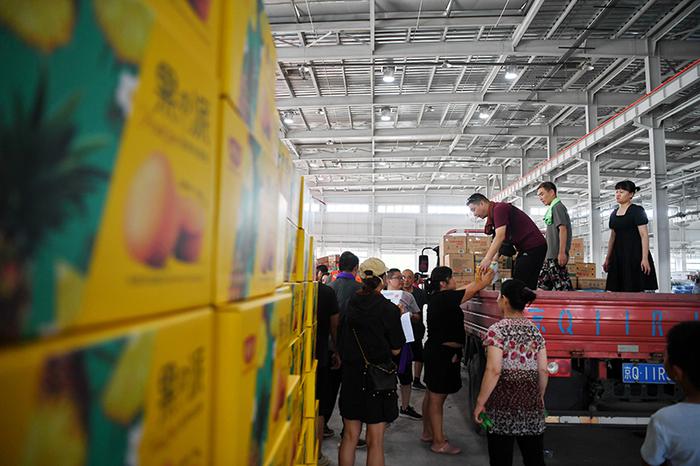 工作人员和志愿者在河北省涿州市钢研物资储备点内将捐赠物资装车外运（8月5日摄）。